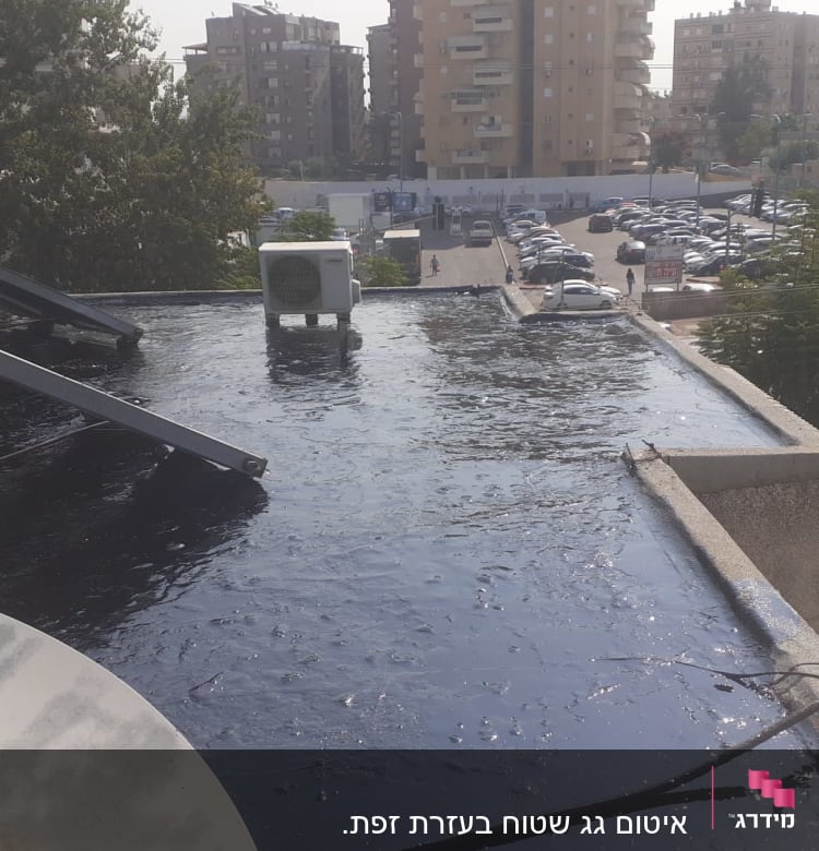גג אטום בזפת עם קולטי שמש ודוד מים